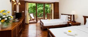 Una habitación de hotel con dos camas y balcón. en Riverhouse Resort, en Mae Sariang 47 fotos más