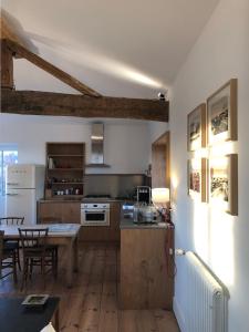 a kitchen with wooden floors and a table in a room at Appartement Parlementia, Phare de Koskenia in Guéthary
