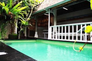 uma piscina com uma mangueira em frente a uma casa em The Pasga Villas Ubud em Ubud