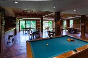 a pool table in a room with tables and chairs at Riverhouse Resort in Mae Sariang