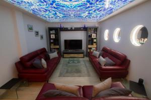 a living room with red couches and a blue ceiling at MEDANO4YOU Casa Violeta in El Médano