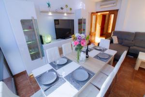 a dining room table with a vase of flowers on it at MEDANO4YOU Casa Violeta in El Médano