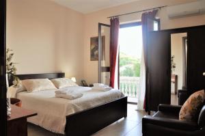 a bedroom with a bed and a chair and a window at Il Belvedere vicino Taormina in Savoca