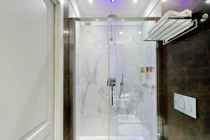 una doccia con una porta in vetro in un bagno di Piazza Venezia Grand Suite a Roma Altre 37 foto