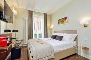 ein Schlafzimmer mit einem großen weißen Bett und einem TV in der Unterkunft Piazza Venezia Grand Suite in Rom