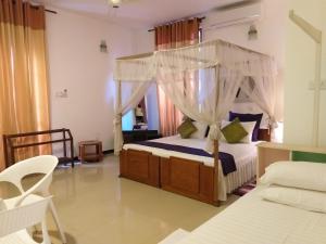 a bedroom with a canopy bed in a room at Cosy Nest Home stay in Negombo