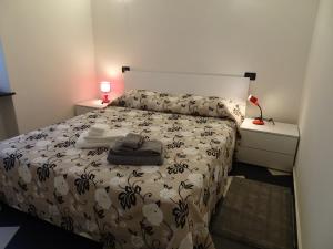 1 dormitorio con 1 cama con edredón blanco y negro en Casa Costa Serena en Génova