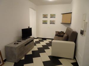 un soggiorno con divano e TV di Casa Costa Serena a Genova