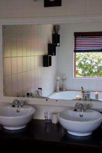 a bathroom with two sinks and a bath tub at Rustic Butler B&B in White River