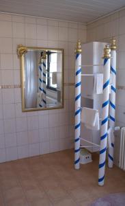 a bathroom with blue and white columns and a mirror at Gästehaus Margerite in Blieskastel