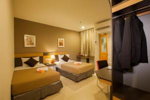 a hotel room with two beds and a couch at LEO Express Hotel in Kuala Lumpur