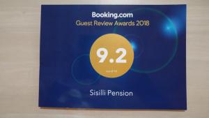 a sign for a guest review awards with a blue and yellow sign at Sisilli Pension in Pyeongchang