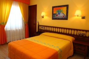 1 dormitorio con 1 cama con manta naranja en Hotel Pipo, en A Lanzada