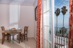 - une salle à manger avec une table et une vue sur l'océan dans l'établissement Apartamentos Plaza Cavana 5, à Nerja