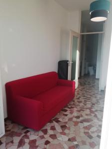 a red couch in a living room with a tile floor at Novegro Linate 101 in Linate