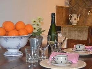 a table with a bowl of oranges and a bottle of wine at Ca S’angel in Biniaraix +14 photos