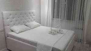 ケメロヴォにあるApartment Pritomskiy prospekt 15の白いベッド(白いヘッドボード、白い枕付)