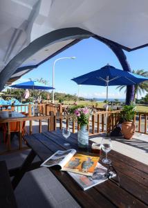 uma mesa com copos de vinho e um guarda-chuva num deque em Kenting Coast Resort em Kenting