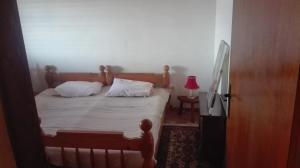 een slaapkamer met een bed met witte lakens en een lamp bij Family apartment Nebojsa in Bar