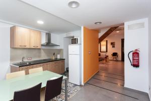 a kitchen with a white refrigerator and a table at Casa Rural "El Paseo del libro" in Sabiote