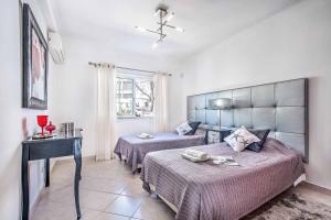 een slaapkamer met 2 bedden, een tafel en een raam bij Villa Jomar in Guia