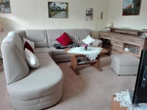 a living room with a white couch and a table at Ferienwohnung Eckoldt in Eisenberg