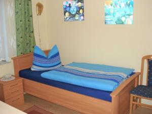 a bed with blue sheets and a blue pillow on it at Ferienwohnung Eckoldt in Eisenberg