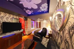 a living room with a tv and a bedroom at Hotel Cherena Kunitachi (Adult Only) in Kunitachi