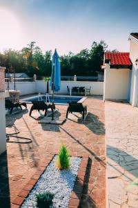 Ružići的住宿－HA-LU 1 - Holiday Relax Home，一个带桌子和蓝伞的庭院