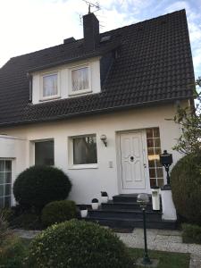 a white house with a white door and stairs at Düsseldorf Messe -Apartment Milan in Düsseldorf