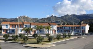 a row of houses with mountains in the background at Nebrodi Park Villa 2 in SantʼAgata di Militello