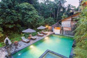 una imagen de una piscina en un complejo en Ani's Villas, en Ubud