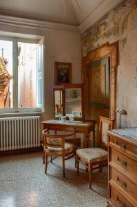 Pokój ze stołem, krzesłami i oknem w obiekcie Residenza storica Volta della Morte w mieście Urbino