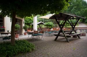 Waldheim的住宿－Waldfrieden Waldheim，一个带桌椅和遮阳伞的庭院