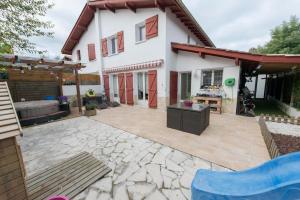 a patio in front of a white house at Hermosa casa con terraza y jacuzzi en Hendaya in Hendaye