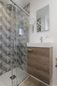 y baño con ducha de cristal y lavabo. en Petit Bijou - Beach apartment III, en Castelldefels