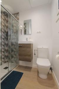 uma casa de banho com um WC e uma cabina de duche em vidro. em Petit Bijou - Beach apartment III em Castelldefels