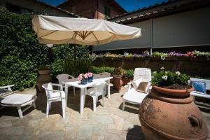 une terrasse avec une table, un parasol et des chaises dans l'établissement I Gelsomini, à Sienne