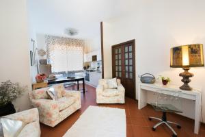 - un salon avec deux chaises et un bureau dans l'établissement I Gelsomini, à Sienne