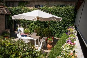 une terrasse avec un parasol, une table et des chaises dans l'établissement I Gelsomini, à Sienne