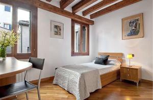 ein Schlafzimmer mit einem Bett und einem Schreibtisch mit einem Stuhl in der Unterkunft Salmaso Apartments in Venedig