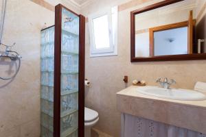 a bathroom with a sink and a toilet and a mirror at Home in Tramuntana in Port des Canonge  +27 photos