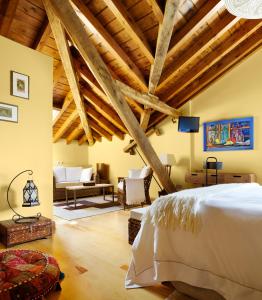 a bedroom with a white bed and wooden ceilings at La Casona del Viajante - Adults Only in Villabajo