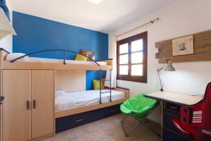 a bedroom with two bunk beds and a desk at Home in Tramuntana in Port des Canonge 