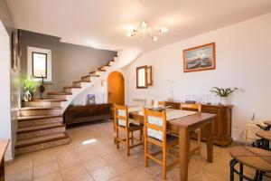 a dining room with a table and a staircase at Home in Tramuntana in Port des Canonge 