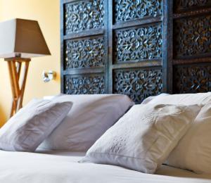 a bed with white pillows and a blue headboard at La Casona del Viajante - Adults Only in Villabajo