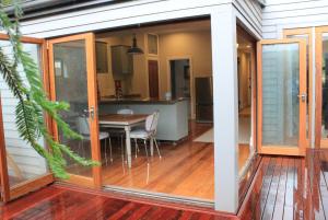 a screened in dining room and kitchen with sliding glass doors at Entwhistle Cottage in Christchurch