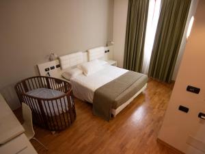 a bedroom with a bed and a chair in it at Master Hotel Reggio Emilia in Reggio Emilia