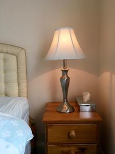 a lamp sitting on a night stand next to a bed at Milka's in Oxford