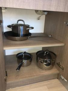 two pots and pans on a shelf in a kitchen at AV Apartment in Rēzekne